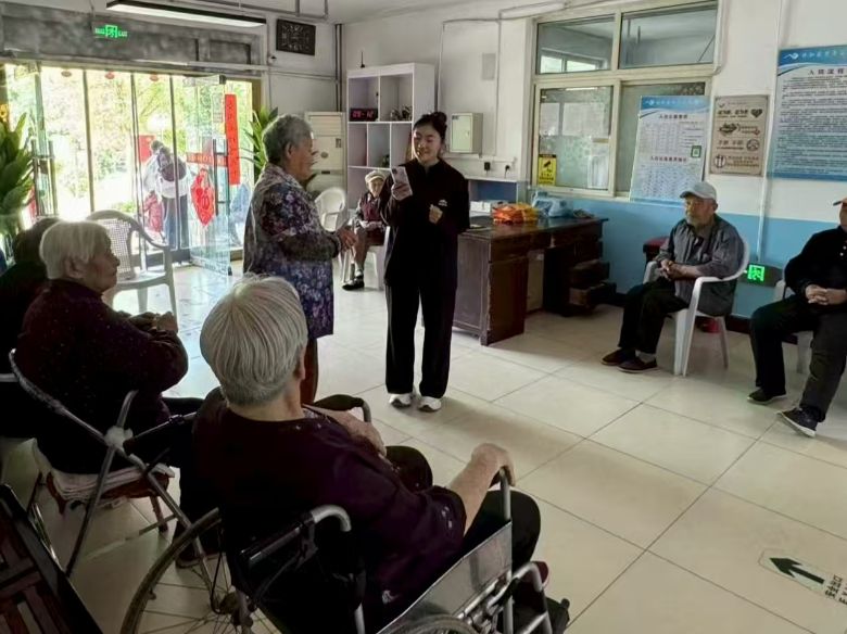 图为实践团成员顾兴羽在老年公寓为老人唱红歌