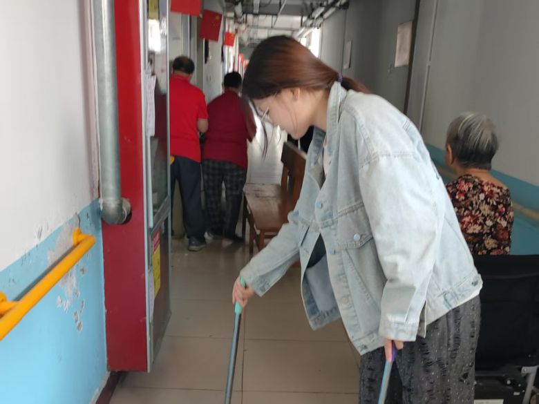 图为实践团成员苗欣语在老年公寓打扫卫生