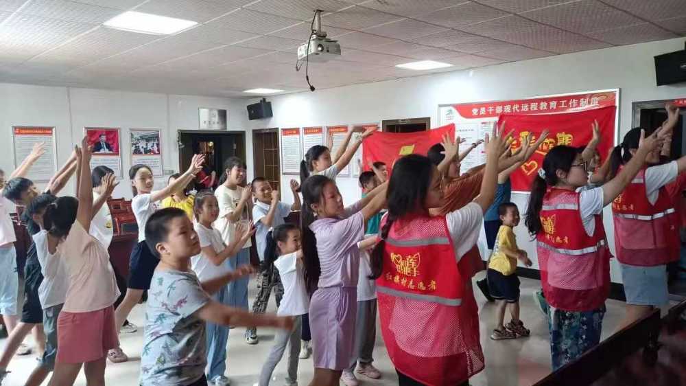图为志愿者与小朋友一起跳热身操