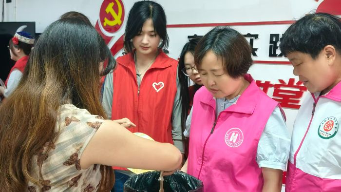图为实践队员协助居民进行国风漆扇染制创作