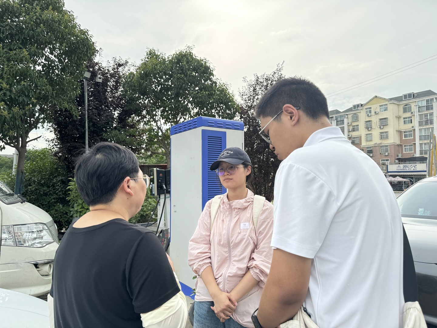 图为实践队成员在充电站随车访谈网约车女司机。侯涵睿 供图