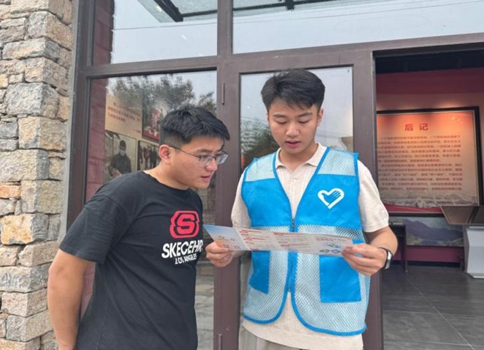 图4:志愿者向群众讲解学生资助政策宣传折页